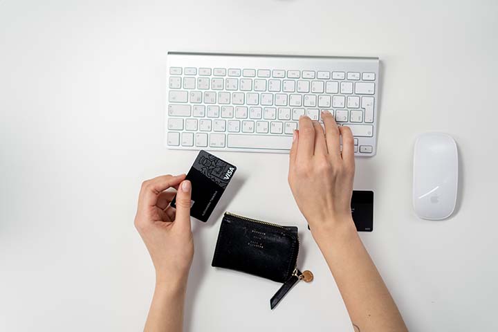best banks for digital nomads - woman typing on keyboard with credit card in hand