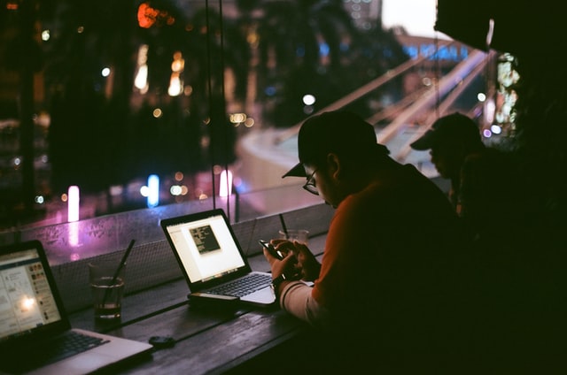  Image of a person working on a laptop at an internet cafe