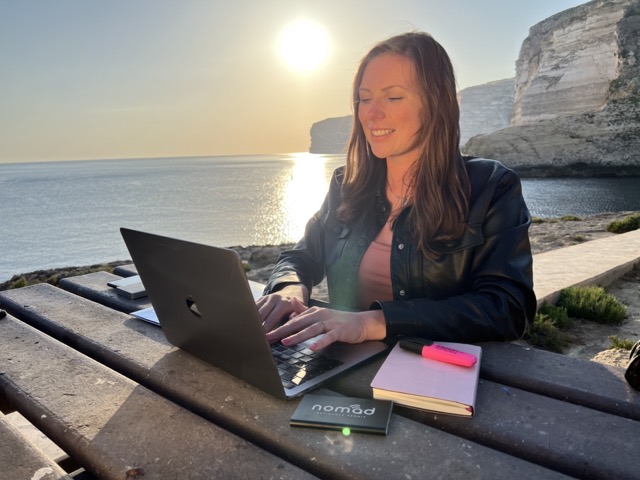 malta digital nomad hotspot - working on computer in front of sunset over the sea