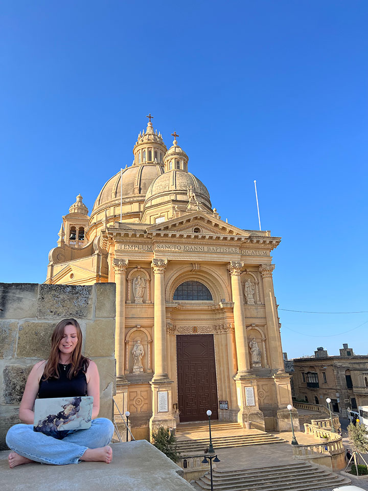 Checking emails in Malta only to realize I was stuck because the wall I was sitting on was too tall